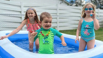 Three children in a kiddie pool Three children in a kiddie pool